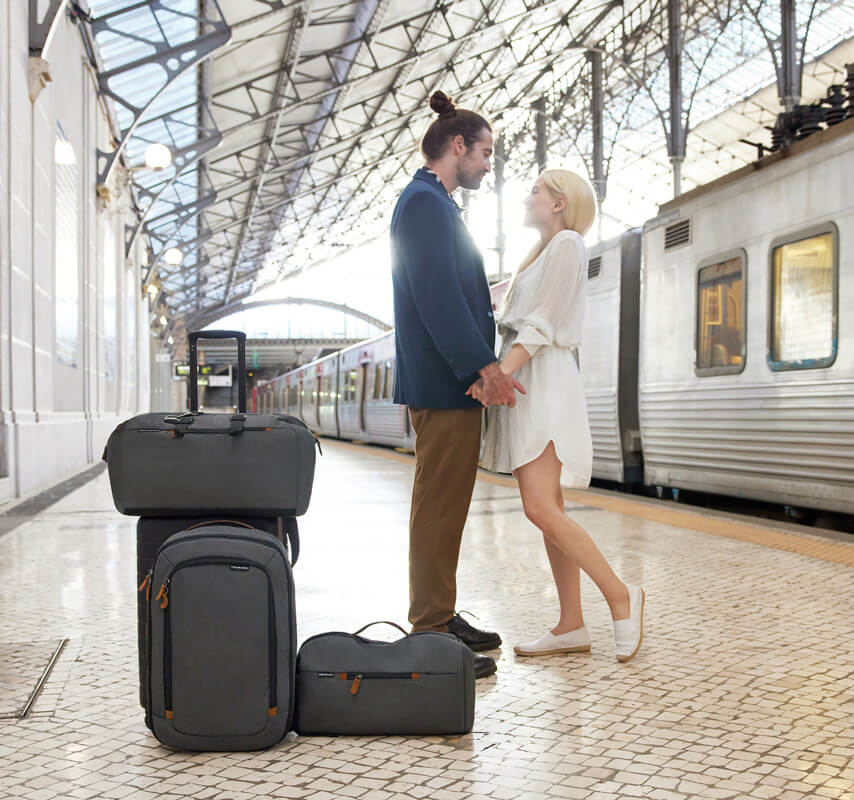 Man and woman with luggage standing on train platform