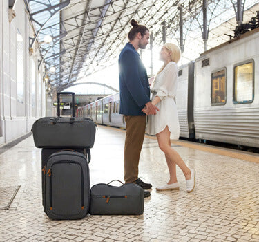 Man and woman with luggage standing on train platform