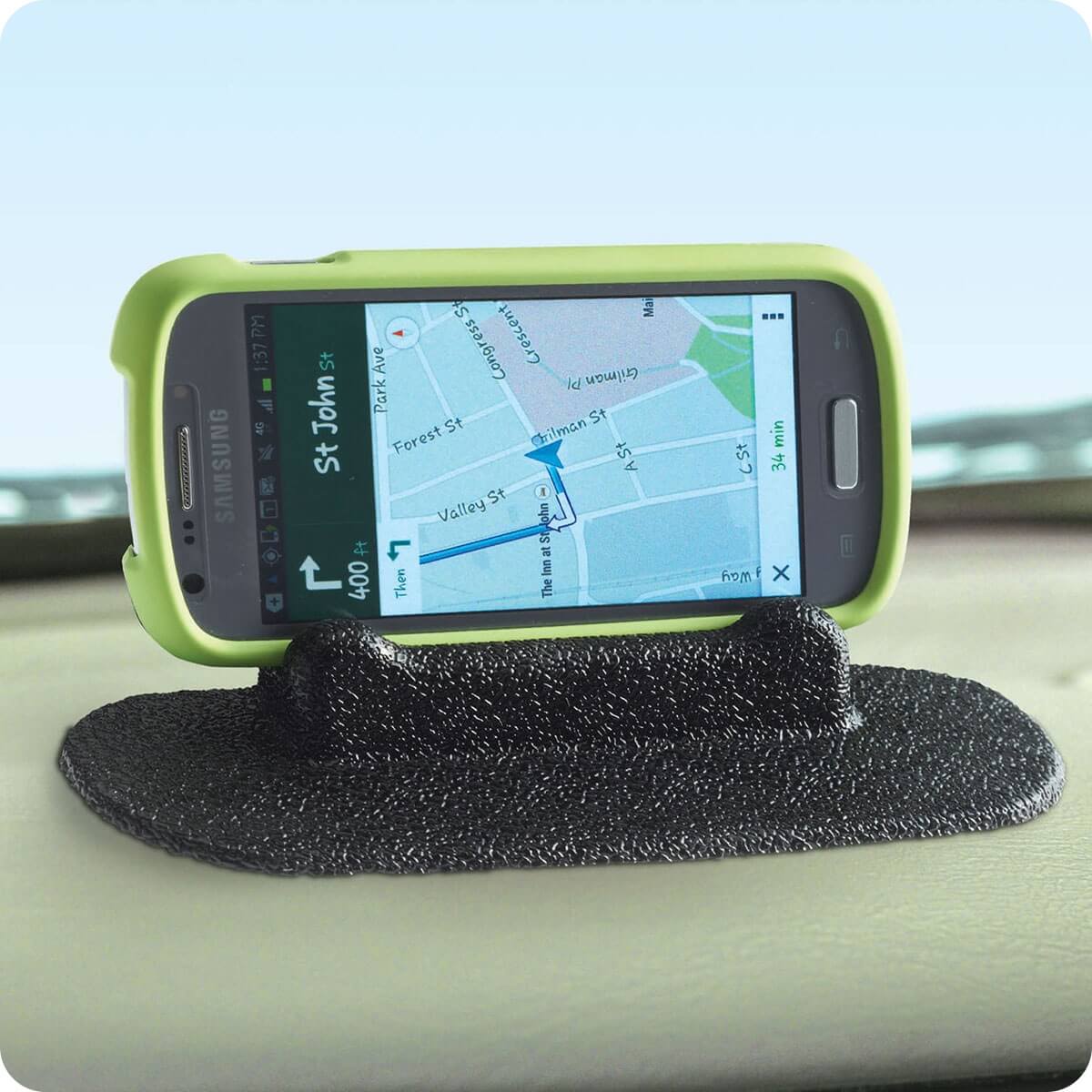 Image showing product molded in black mounted on a vehicle dashboard and holding a smartphone displaying a GPS map.